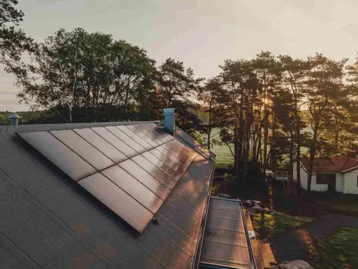Solpaneler på ett tak i solnedgången, en vacker vy av Svea Solar AB:s arbete.