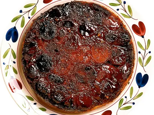 En härlig aprikoskaka upp och ner, med karamelliserad yta och saftiga aprikoser, serverad på en vackert dekorerad tallrik.