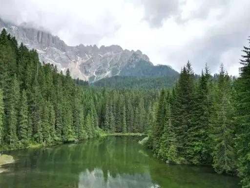 Laghi alpini nella Val di Fassa, circondati da fitti boschi di conifere e imponenti vette rocciose.