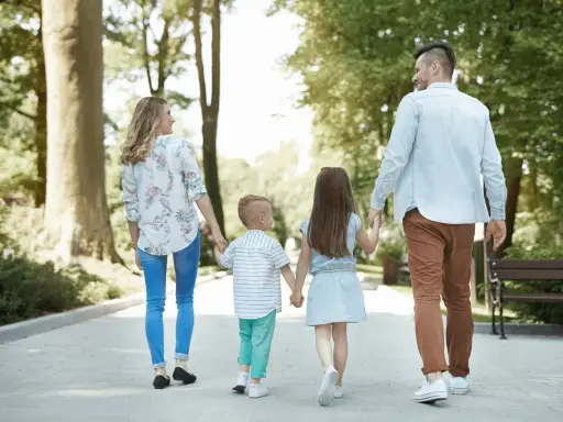 Familia paseando por un parque, ideal para saber qué hacer en León con niños y disfrutar del aire libre.