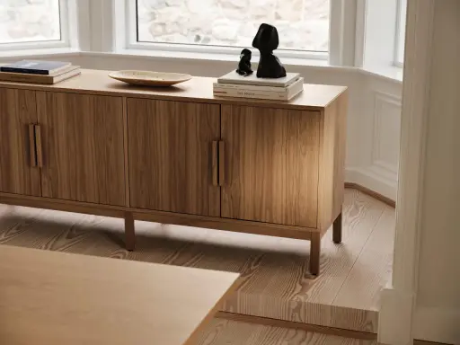 Ett vackert sidobord i trä med böcker och skulpturer på. Perfekt för att styla ditt hem.