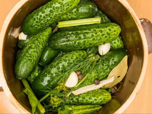 Ogórki małosolne w glinianym naczyniu z koprem, czosnkiem i liściem laurowym. Zastanawiasz się, ile kalorii ma ogórek małosolny?