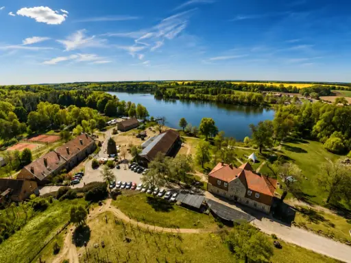 Agroturystyka nad jeziorem, gdzie można podziwiać piękne krajobrazy i odpocząć. W oddali widać pola rzepaku.