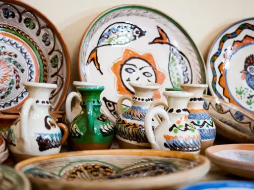 Collection de poteries peintes à la main, dont des cruches et des assiettes décorées, des pièces recherchées de Vallauris.