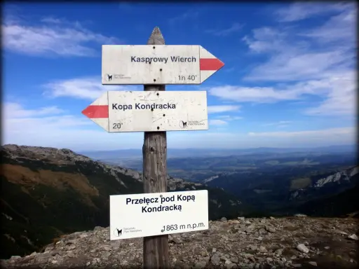 Droga na Kopę Kondracką. Znaki wskazują kierunek i czas dojścia. Widok na Tatry.