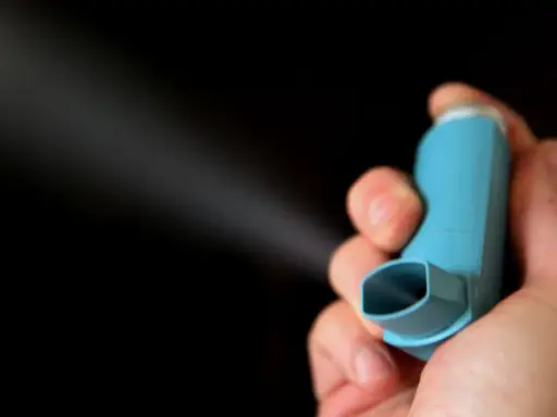 Hand hält blauen Inhalator, der Nebel versprüht. Informationen zu brimica genuair nebenwirkungen sind wichtig.