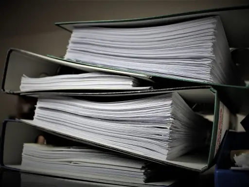 Stosy dokumentów w segregatorach. Może to być materiał do analizy, ale też dowód na to, że popełniono błąd i teraz potrzebny jest czynny żal.
