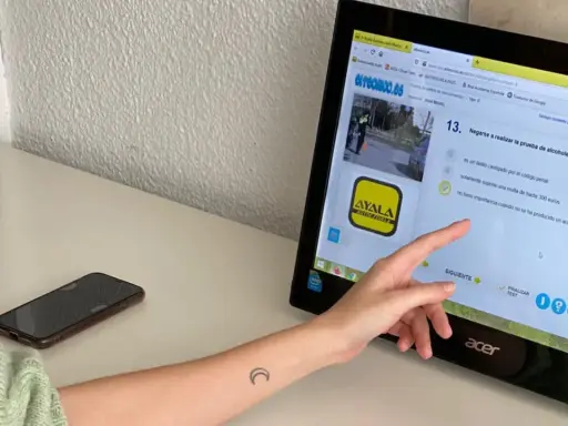 Persona estudiando para el examen teórico de conducir, resolviendo preguntas sobre multas y delitos. Averigua cuántos fallos se pueden tener en el examen teórico de conducir.