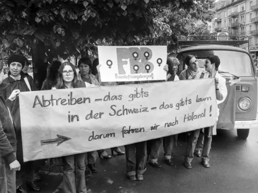 Frauen demonstrieren für das Recht auf Abtreibung. Die Botschaft "Abtreiben – das gibts in der Schweiz – das gibts kaum, darum fahren wir nach Holland!" zeigt eine frühe Welle des Feminismus.