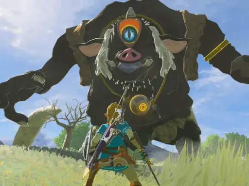 Link z gry Zelda Breath of the Wild staje naprzeciw gigantycznego Guardian'a na tle błękitnego nieba.