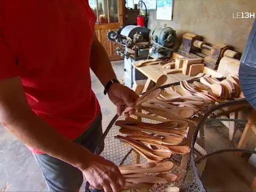 Un artisan du bois, maître dans son métier de tabletier, présente une collection de cuillères en bois faites à la main.