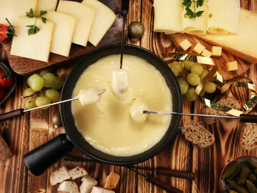 Fondue au fromage, une des spécialités d'Auvergne, accompagnée de pain, raisins et tomates cerises.