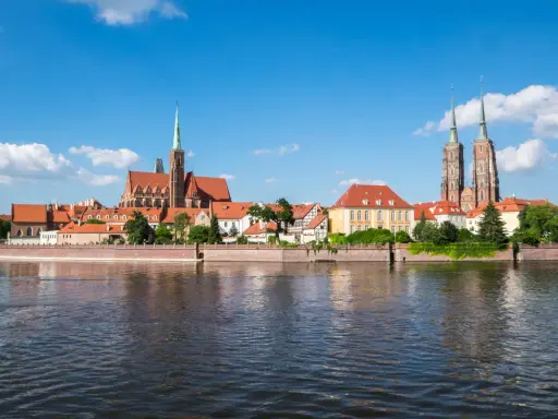 Widok na Ostrów Tumski we Wrocławiu, perłę Dolnego Śląska, z rzeką w tle.