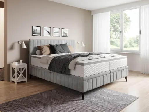 Sovrum med en stor säng i grått tyg. En fin balans att blanda beige och grått inredning med detaljer i trä och svarta tavlor på väggen.