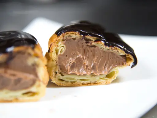 Éclairs généreusement garnis de crème pâtissière chocolat, nappés d'un glaçage brillant. Un délice gourmand.