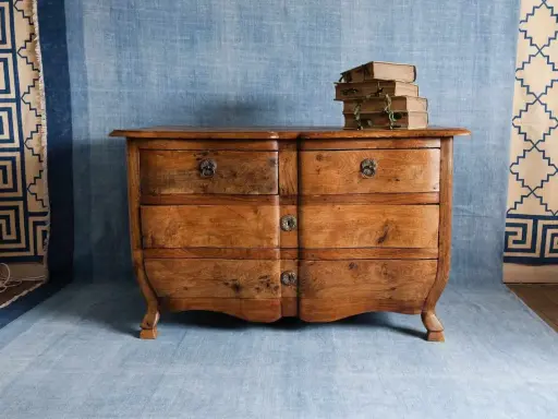 Cómoda antigua de madera, lista para restaurar muebles antiguos. Apilados libros viejos encima.