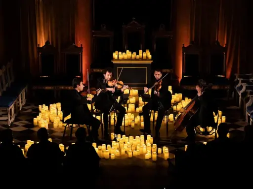 En stråkkvartett spelar bland hundratals levande ljus under en magisk candlelight concert.