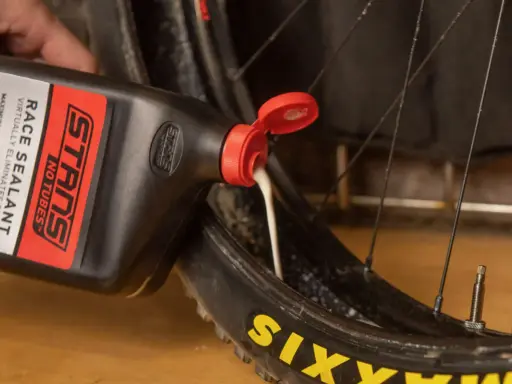 Wlewanie uszczelniacza do opony rowerowej. Płyn do opon tubeless zapewnia ochronę przed przebiciami.