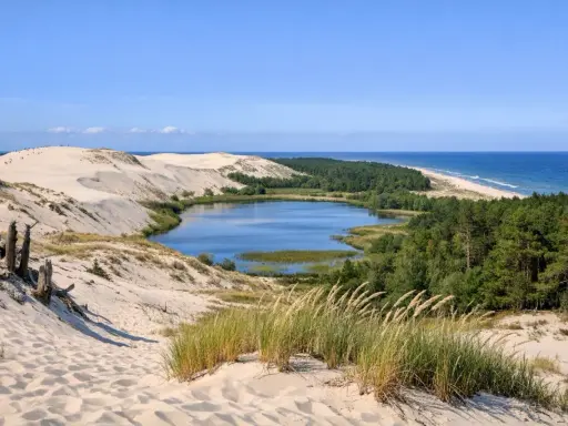Słowiński Park Narodowy atrakcje: ruchome wydmy, jezioro Łebsko, lasy i morze. Widok z wydmy na krajobraz.
