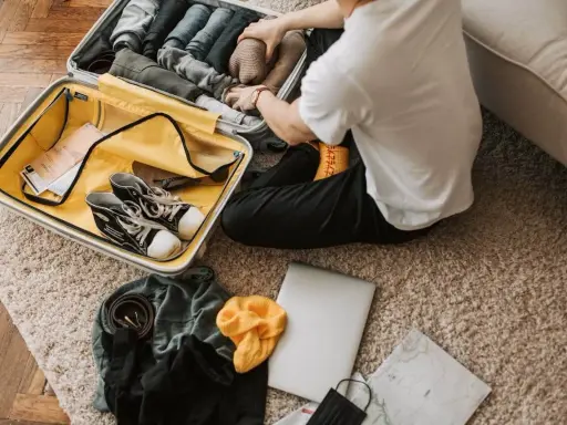 Pakowanie walizki: ubrania, buty, laptop, mapa. Zastanawiasz się, co zabrać na wakacje? Oto inspiracja!