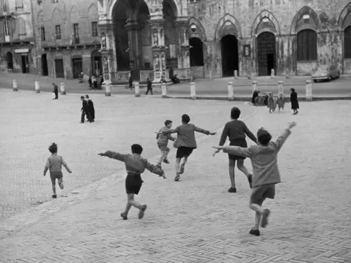 Bambini corrono in una piazza storica, un'immagine piena di movimento e gioia, perfetta come idee per foto.