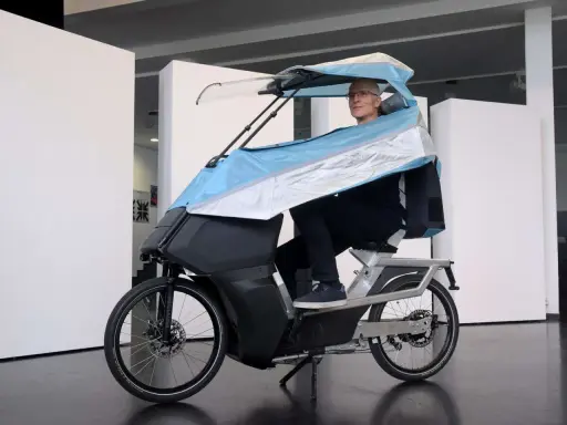 Mann auf einem E-Bike mit Dach, das an ein Auto erinnert.