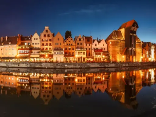 Nadmorska panorama Gdańska nocą, z odbijającymi się w wodzie kamienicami i Żurawiem. Idealne miejsce na zaręczyny Polska.