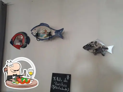 Décoration murale en forme de poisson au restaurant Le Saint Pierre La Tronche. Assiette de fruits de mer et verre de vin.