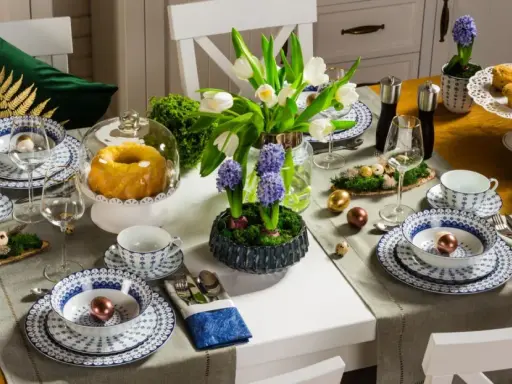 Stół wielkanocny inspiracje: białe tulipany, hiacynty, babka, babeczki, złote i miedziane jajka, porcelana z niebieskim wzorem.