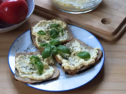 Chleb z pastą jajeczną jak dawniej, ozdobiony bazylią. Smak dzieciństwa na talerzu.