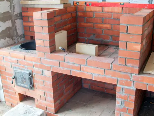 Construcción de diversos tipos de chimeneas de obra, con ladrillos rojos y detalles metálicos.