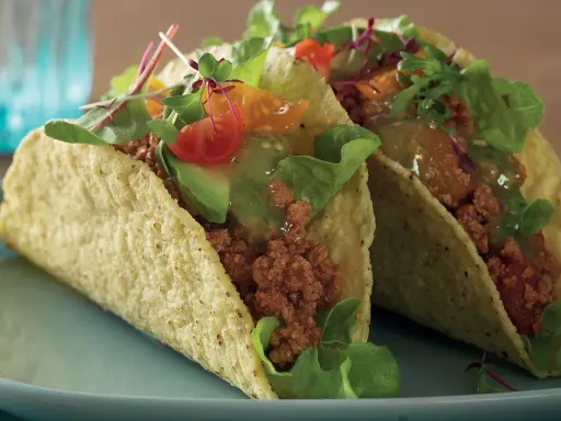 Två läckra vegetariska tacos med avokado, tomat och grönsaker. Perfekt för en snabb och smakrik måltid.