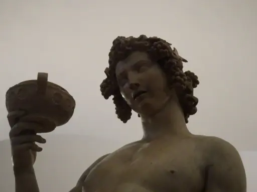 Bacchus, jeune dieu du vin, couronné de grappes, tient une coupe. Une œuvre d'art inspirée par Michel-Ange.