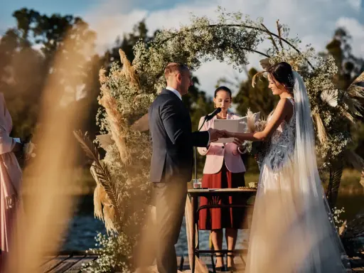 Piękna ceremonia ślubna na świeżym powietrzu. Para młoda wymienia obrączki, a urzędniczka udziela im ślubu. Inspirujące pomysły na ślub cywilny.