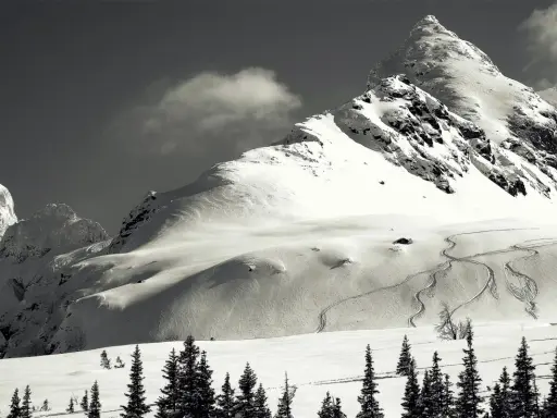 Śnieżny polski Matterhorn, majestatyczna góra w zimowej scenerii, z widocznymi śladami nart na zboczu.