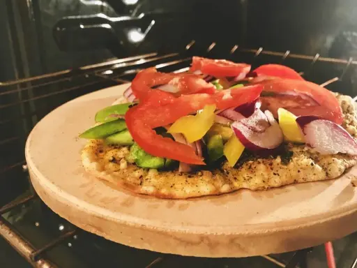 Pizza na kamieniu w piekarniku, z pomidorami, papryką i cebulą. Po pieczeniu dowiedz się, jak umyć kamień do pizzy.