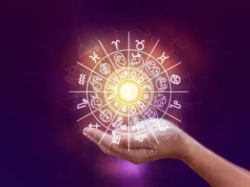 Obracający się znak zodiaku nad dłonią, zapowiadający horoskop na weekend.