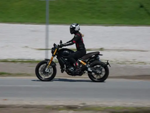 Kobieta w kasku i kombinezonie jedzie motocyklem spełniającym normę **euro 4**.