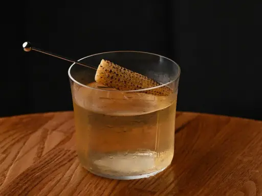 Szklanka z drinkiem i kawałkiem kukurydzy, intrygująca zapowiedź tego, jak smakuje brandy.
