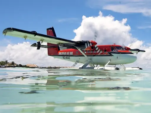 Ein rotes Twin Otter Flugzeug schwimmt auf dem Wasser vor den Malediven.