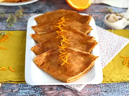 Färdigstekta crêpes, vikta och prydda med apelsinskal. Ett perfekt crepes recept för en härlig frukost eller dessert.