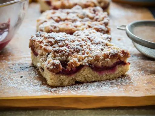 Saftiger Pflaumenkuchen vom Blech, bestäubt mit Puderzucker. Ein köstliches Rezept für den Herbst.