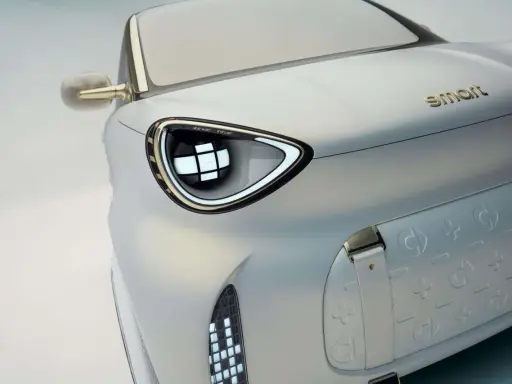Dettaglio di un'auto elettrica Smart, con un faro futuristico e il logo dorato. Nuovi modelli in arrivo.