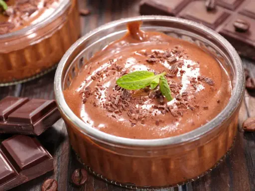 Mousse au chocolat Marie Morin recette : un délice onctueux, garni de copeaux de chocolat et d'une feuille de menthe, prêt à être dégusté.