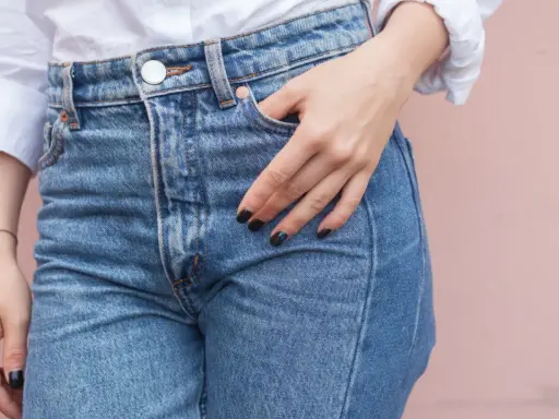 En hand vilar i fickan på ett par ljusblå jeans. Kanske är det en ny trend, jeans i frysen, för att få dem extra krispiga?