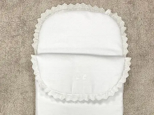 Patrón saco bebé capazo blanco con encaje y iniciales GG bordadas. Perfecto para un dulce descanso.