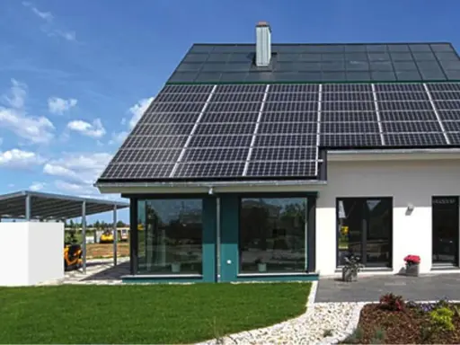 Ein modernes, energieautarkes Haus mit Solarmodulen auf dem Dach und einer Photovoltaik-Anlage auf dem Carport.