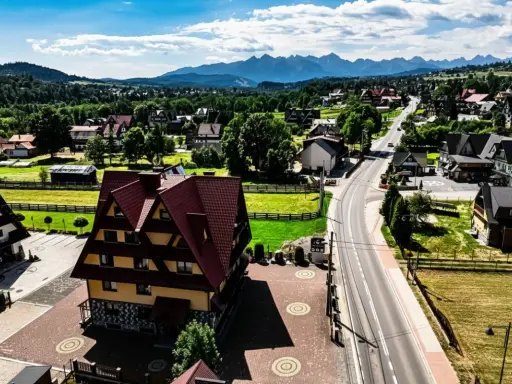 Malownicze tatrzańskie miejscowości z charakterystyczną architekturą i górami w tle.