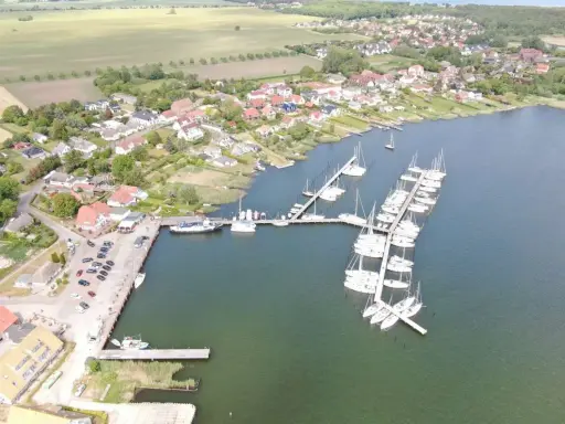 Breege Hafen: Viele Segelboote liegen im Hafen von Breege, umgeben von Häusern und grünen Feldern.