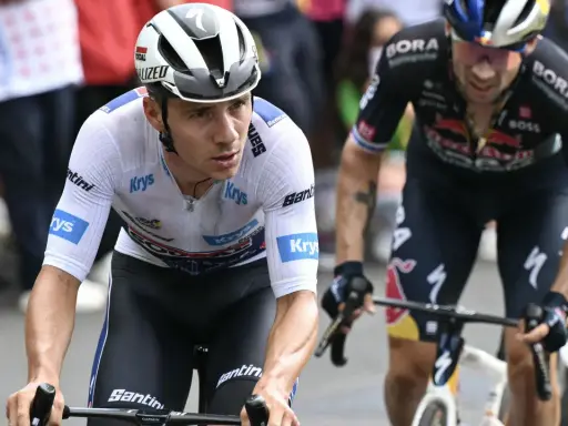 Remco Evenepoel im Rennen, sein Gehalt ist ein Thema, das Fans und Experten gleichermaßen interessiert. Er fährt konzentriert auf seinem Rad.